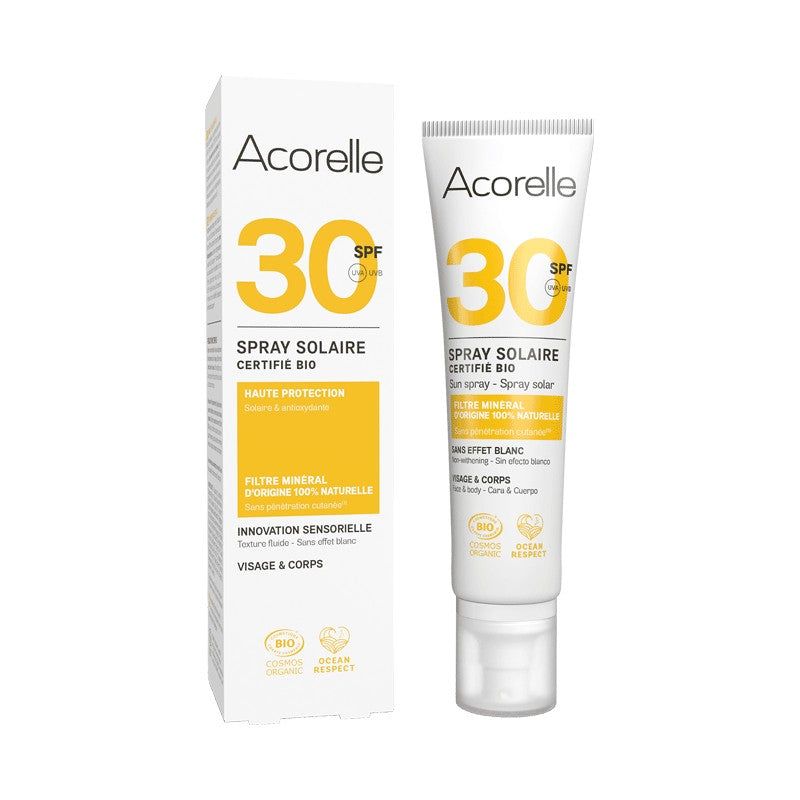 Acorelle Aurinkosuojasuihke Kasvoille ja Vartalolle SPF30: valkoinen ja keltainen Spray Solaire -tuubi yhteensopivan pakkausrasian vieressä; molemmissa sileä mattapinta ja suorakulmainen, pyöristetyin reunoin muoto; etiketissä suuret oranssit "SPF 30" -numerot lihavoidulla groteskikirjasimella, tekstiä ranskaksi ja englanniksi mustalla ja harmaalla; tausta on valkoinen, ei ihmisiä tai käsiä näkyvissä.