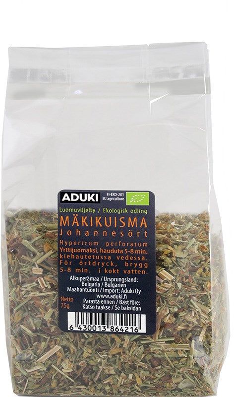 Aduki Luomu Kuivattu Mäkikuisma; läpinäkyvä muovipussi sisältää pilkottuja vihreitä ja ruskeita yrttejä, merkitty Aduki-brändin luomu-mäkikuisma-yrttiteeksi; suorakulmaisessa pussissa mattapintainen etiketti painettuna suomeksi ja ruotsiksi yksinkertaisin groteskikirjaimin; pakkaus lepää tasaisella pinnalla, kuvattu suoraan edestä, ei ihmisiä tai käsiä näkyvissä.