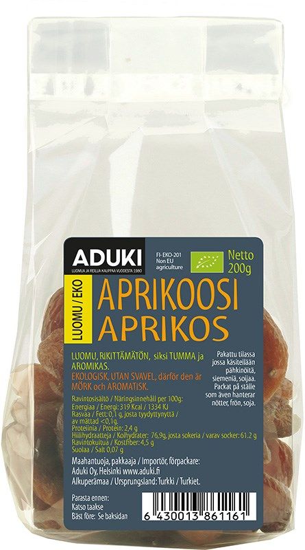 Aduki Luomu Kuivattu Aprikoosi; kirkas muovipussi Aduki-merkkisiä luomu-kuivattuja aprikooseja mattapinnalla, suorakaiteen muotoinen, tumma etiketti näyttää sekä suomen- että ruotsinkielistä tekstiä; aprikoosit näkyvissä pakkauksen läpi; viivakoodi 200 g pussin alaosassa; ei ihmisiä tai käsiä; tuote kuvattu neutraalilla taustalla yksinkertaisessa otoksessa.