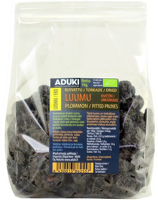 Aduki Luomu Kuivattu Luumu; kirkas muovipussi Aduki-merkkisiä luomu kuivattuja kivettömiä luumuja, sinis-keltainen etiketti useilla kielillä; suljettu 1 kg pussi näyttää tummia luumuja sisällä, pinnassa sekä matta- että kiiltäväalueita; etikettitekstissä tuotenimi ja paino useilla kielillä lihavoiduin yksinkertaisin fontein; tuote kuvattu valkoisella taustalla, ei näkyviä ihmisiä tai muita esineitä.