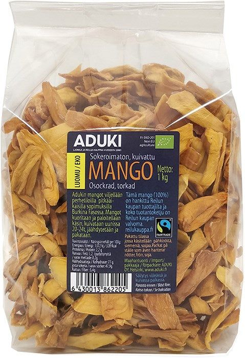 Aduki Luomu Kuivattu Mango; kirkas muovipussi Aduki-merkkisiä kuivattuja mangoviipaleita, sinis-keltainen etiketti näyttää tuotetietoa useilla kielillä, mukaan lukien ainesosat; etiketissä groteskifontteja valkoisena ja mustana, lohkokirjaimin brändinimelle; kuivatut mangoviipaleet oransseja ja epäsäännöllisen muotoisia; pakkaus suljettu vaakasuoralla saumalla yläosassa; valkoinen tausta, ei ihmisiä tai rekvisiittaa.
