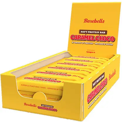 Barebells Soft Caramel Choco Proteiinipatukka; keltainen laatikko Barebells Caramel Choco -pehmeitä proteiinipatukoita varten, kansi avattuna paljastaen siististi aseteltuja yksittäin käärittyjä patukoita; laatikko suorakaiteen muotoinen, mattapinta, pahvia; pakkauksessa lihavoitua valkoista ja ruskeaa groteskitekstiä brändille ja tuotenimelle; valkoinen tausta, ei ihmisiä tai käsiä.