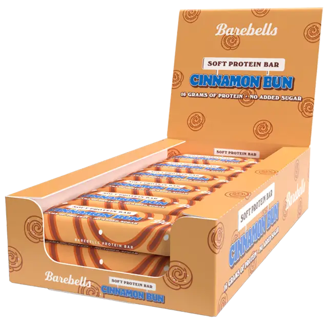 Barebells Soft Cinnamon Bun Proteiinipatukka; avoin rasia Barebells Cinnamon Bun -pehmeitä proteiinipatukoita näyttää useita yksittäin käärittyjä patukoita oranssissa ja sinisessä kiiltopakkauksessa; suorakulmainen pahvirasia ja kääreet lihavoidulla groteskitekstillä ”16 grams of protein” ja ”no added sugar”; ei ihmisiä tai käsiä; valkoinen tausta.