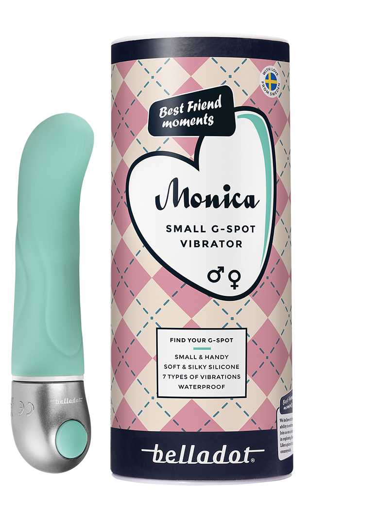Belladot Monica Small G-piste Vibraattori: turkoosi vibraattori esillä sylinterimäisen pakkauksensa vieressä sydänkuvituksin ja tuotetiedoin; vibraattorin pinta on sileä ja mattaa, muoto kaareva kapenevalla kärjellä; pakkaus on pystyasennossa groteskikirjasimella ja ääriviivakuvitetuin sydämin; tausta on valkoinen, ei ihmisiä tai käsiä näkyvissä, tavanomainen edestäpäin otettu tuotekuva.