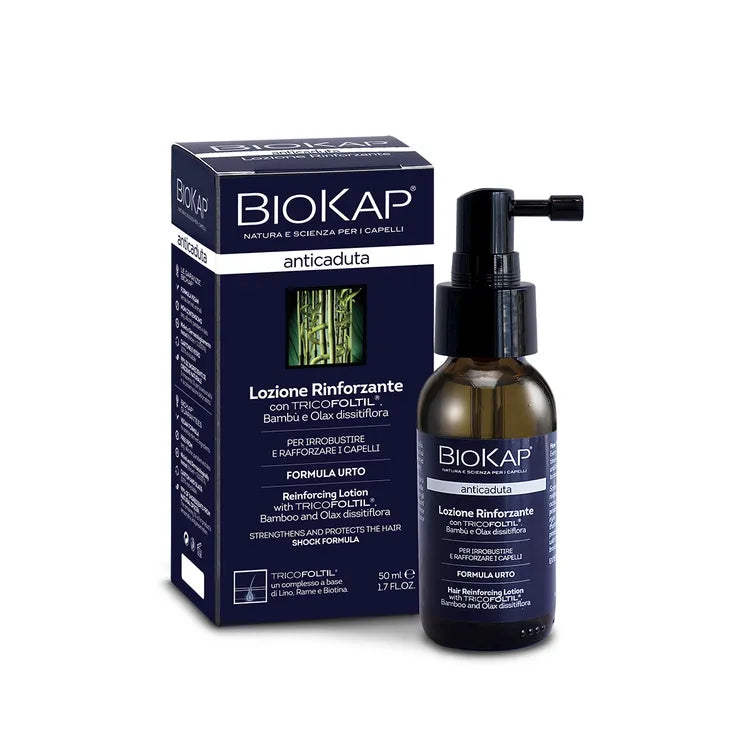 Biokap Anticaduta Hiusseerumi; pullo ja rasia Biokap Reinforcing Lotion -hiustuotetta pumppuannostelijalla; sekä pullo että rasia sinisiä valkoisin tekstein ja vihreä bambukuva, kuvattuna tasaisella taustalla; pakkausten pinnat vaikuttavat mattapintaisilta; etiketissä brändinimi, tuotetyyppi, tilavuus (50 ml / 1,7 fl. oz) ja pääkäyttötarkoitus tikkukirjasimella; ei ihmisiä tai muita esineitä näkyvissä.
