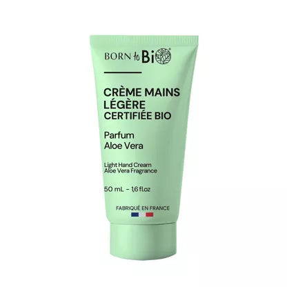 Born to Bio Light Hand Cream: vihreä Born to Bio Light Hand Cream -tuubi aaloetuoksulla, 50 ml, ranskan- ja englanninkielinen teksti sekä Ranskan lippu alaosassa; tuubi seisoo pystyssä mattapinnalla ja pyöristetyllä korkilla; groteskikirjasin; etiketissä brändinimi ja tuoksukuvaus; tausta on valkoinen pehmeällä valaistuksella, ei ihmisiä tai käsiä näkyvissä, lähikuva kokonaan kehyksessä.