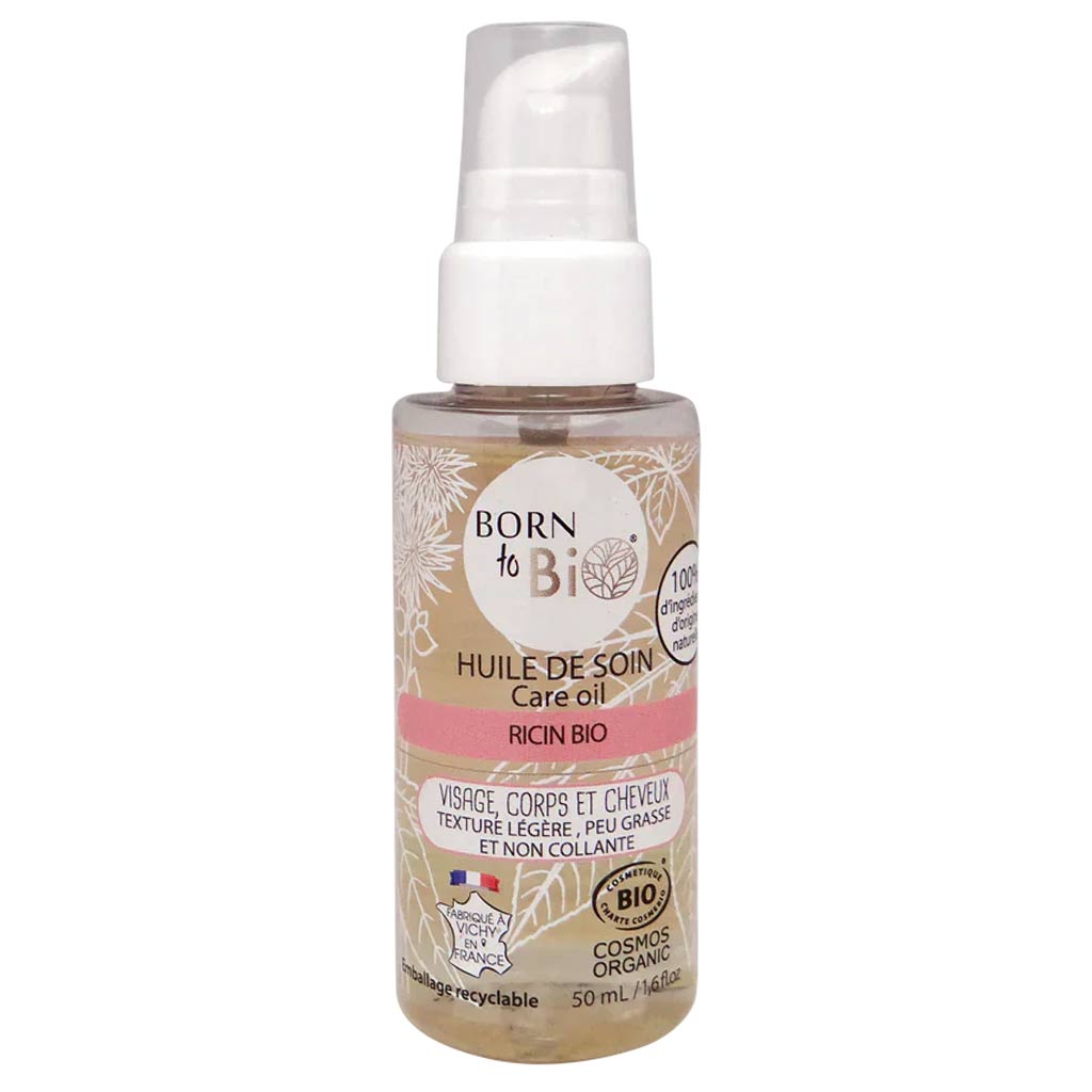 50 ml:n Born to Bio -hoitoöljypullo pumppuannostelijalla, merkinnät kasvoille, vartalolle ja hiuksille; lieriömäinen muovipullo kiiltäväpinnalla, pinkin ja valkoisen väriblokitus, etiketissä lukee luomuris iiniöljy; sertifikaattilogot painettu alaosaan; luettavaa groteskikirjasinta mustana ja pinkkinä; tausta valkoinen, ei ihmisiä tai käsiä kuvassa.