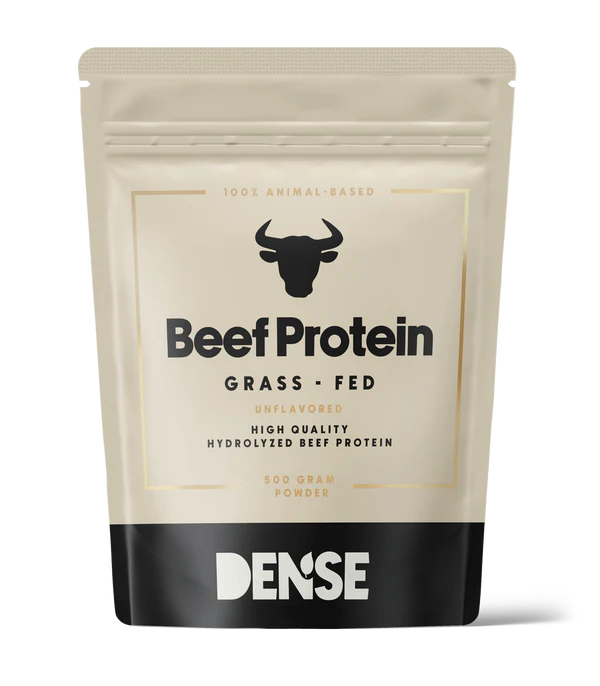 DENSE Nautaproteiini Maustamaton; beige ja musta uudelleensuljettava pussi, merkitty Beef Protein Grass-Fed, sonnin pään kuvake; pussi on mattapintainen, suorakulmainen ja seisoo pystyssä; typografia mustaa ja valkoista groteskia; alareunassa näkyvät avainsanat Unflavored, 500 gram powder ja Dense; ei ihmisiä tai käsiä näkyvissä; tausta valkoinen tasaisessa valaistuksessa.