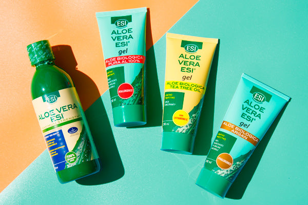 ESI Aloe Vera Geeli; neljä vihreää ESI Aloe Vera -geelituubia kiiltäväpintaista muovia, kapeneva muoto ja läppäkorkit, aseteltuna vinottain taustalle, joka on jaettu keltaiseen ja turkoosiin puoliskoon; auringonvalo luo selkeitä varjoja tuotteiden taakse; etiketeissä siistiä groteskitypografiaa, mainiten puhtaan aloe veran tai lisättyjen vitamiinien ainesosina; ei ihmisiä eikä käsiä näkyvissä.