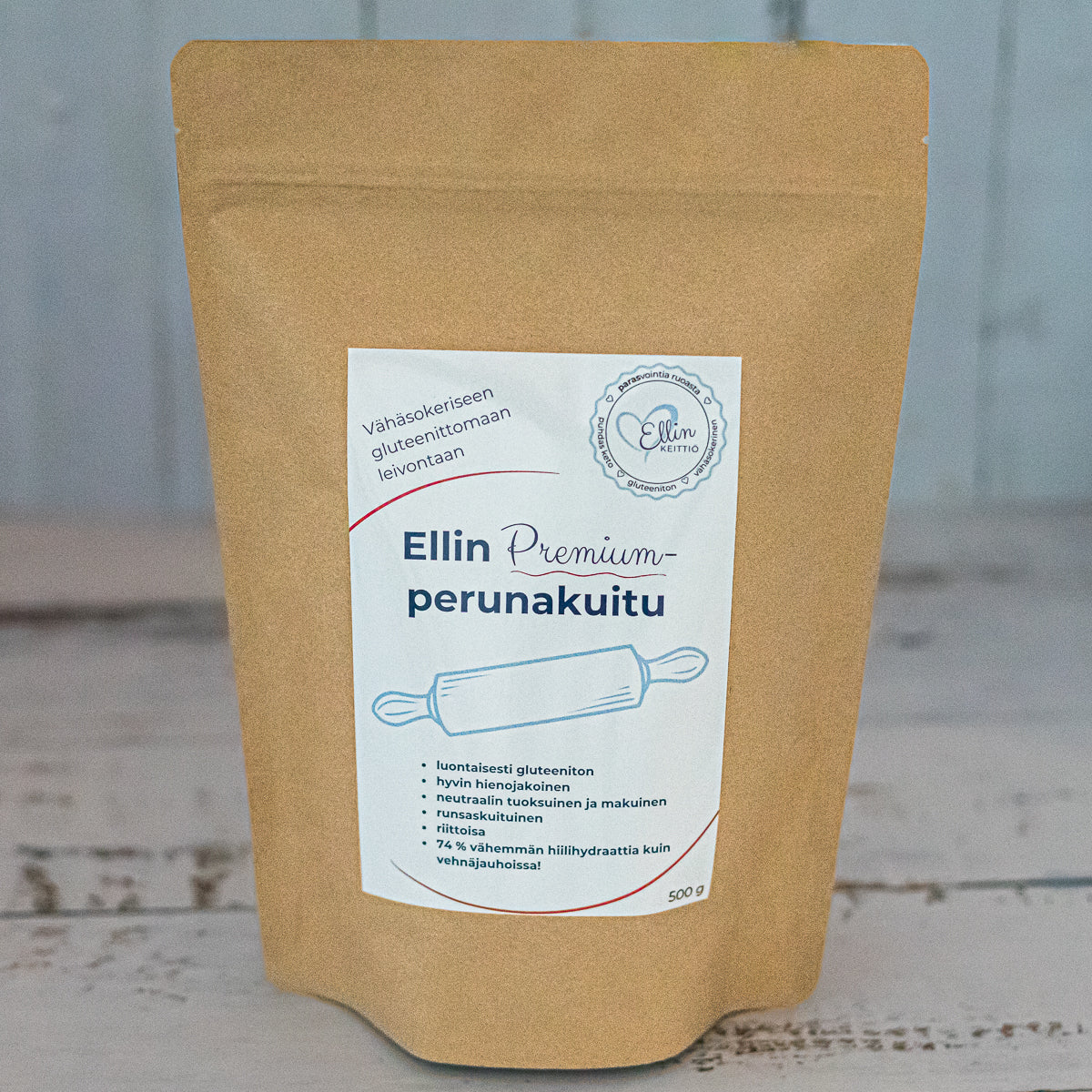 Ellin Premium Perunakuitu; ruskea, mattapintainen paperipakkaus, jossa lukee "Ellin Premium Perunakuitu", seisoo pystyssä vaalealla puupöydällä; pakkaus on suorakulmainen, litteäpohjainen ja saumat suljetut; valkoisessa etiketissä sinistä groteskitekstiä ja kuvitettu kaulin; ei ihmisiä tai käsiä näkyvissä; studiotuotekuva neutraalilla taustalla.