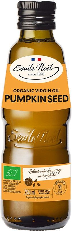 A bottle of Emile Noël Organic Virgin Pumpkin Seed Oil, 250ml, with a brown glass design and an orange label highlighting its organic qualities and a secure cap. The bottle has a cylindrical shape with smooth, glossy surface; the orange paper label wraps around the front, displaying the brand name in serif font. There are no people or actions visible. The background is plain and light-colored.