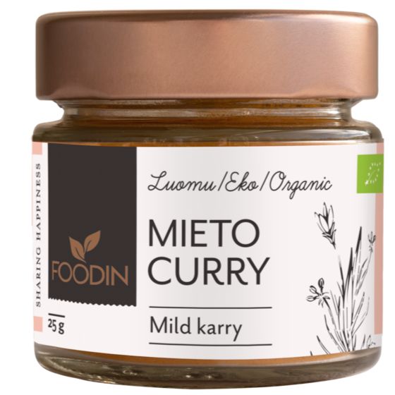 A glass jar of Foodin brand organic mild curry spice blend, 25g, with a copper-colored metallic screw-on lid and a cylindrical shape. The white matte label wraps around the jar, displaying botanical illustrations and bilingual Finnish and English text in simple sans-serif fonts. The product stands on a plain surface with no visible background elements.