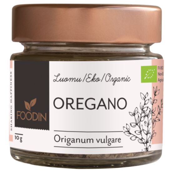 Foodin Luomu Oregano; pieni lasipurkki, metallinen kuparinvärinen kierrekansi, lieriömäinen läpinäkyvä runko; mattapintainen valkoinen etiketti kiertää purkkia, esittää brändin "Foodin", tuotenimen ja vihreitä yrttikuvituksia; yksinkertaista groteskitekstiä; vaalea tausta, ei toimintaa tai ihmisiä kuvassa.