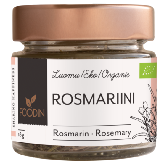 Foodin Luomu Rosmariini, lasipurkki ruusukultaisella metallikannella, sylinterin muotoinen ja läpinäkyvä, sisällä näkyy kuivattua rosmariinia; purkin pinta kiiltävä; etiketti tumma ja mattapintainen, valkoista groteskitekstiä suomeksi, saksaksi ja englanniksi, tuotenimi ja paino (18 g) sekä yksinkertaisia vihreitä kasvikuvituksia; tausta studiomainen valkoinen, ei ihmisiä eikä käsiä.