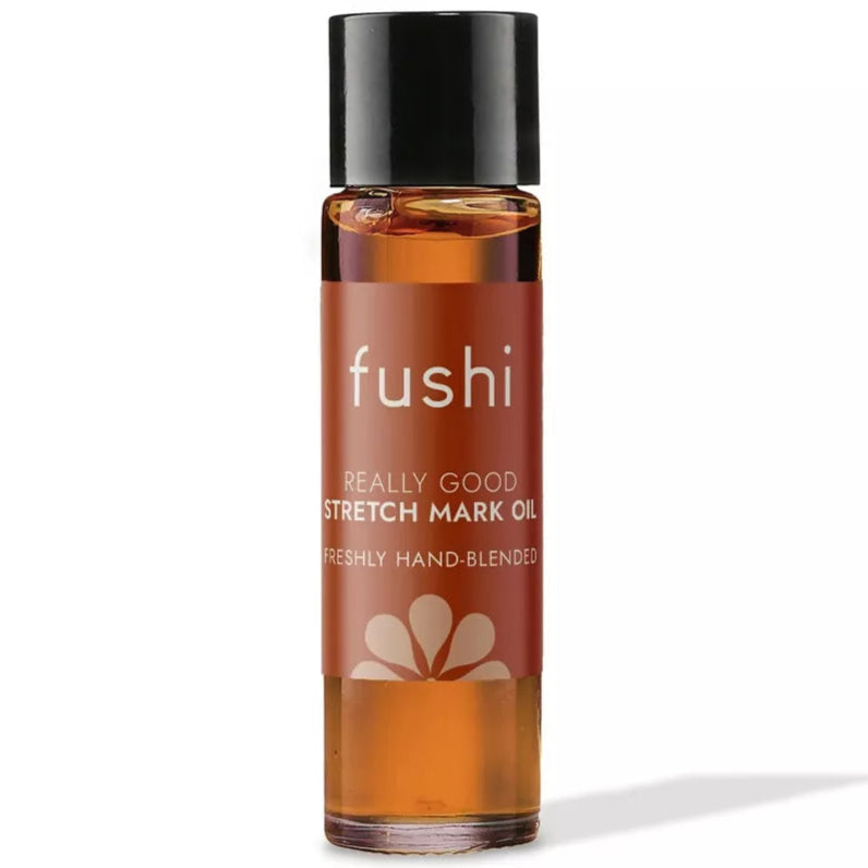 Fushi Raskausarpiöljy; pieni meripihkanvärinen lasipullo, jossa musta kierrekorkki, pystyasennossa valkoisella taustalla; etiketissä teksti ”fushi REALLY GOOD STRETCH MARK OIL FRESHLY HAND-BLENDED”; lieriömäinen muoto, kiiltävä pinta; ei ihmisiä, käsiä tai muita rekvisiittoja kuvassa.