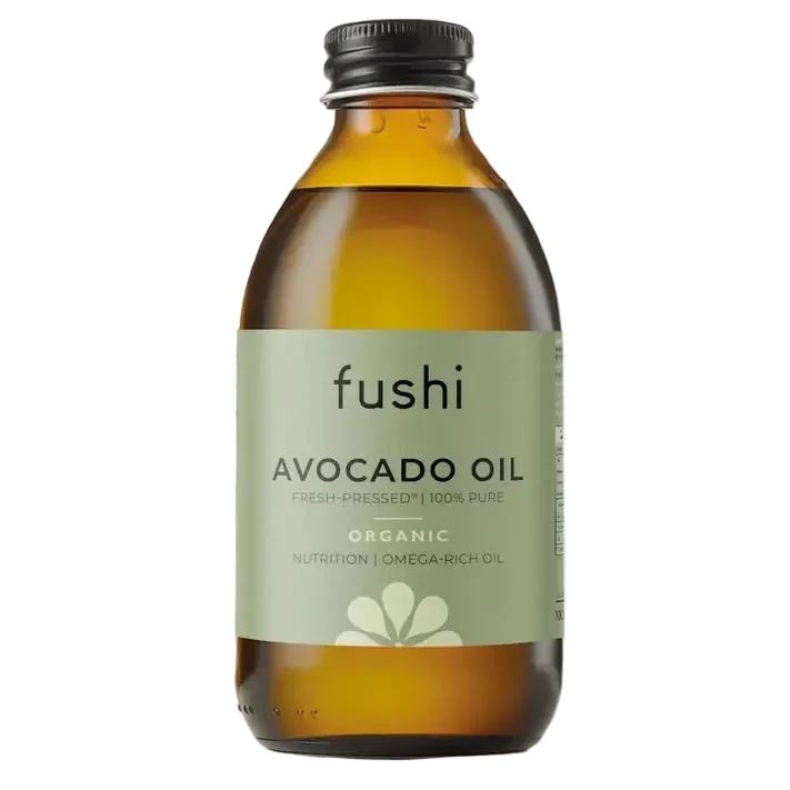 Ruskea lasipullo kiiltäväpinnalla, lieriömäinen ja musta muovikorkki. Etiketti on vihreä valkoisin ja mustin pääteviivattomin tekstein, ja päätekstinä näkyy fushi Avocado Oil Organic. Tuote on kuvattu yksin pelkistettyä taustaa vasten tavanomaisessa edestäpäin otetussa kuvassa. Pullo sisältää tuorepuristettua, 100-prosenttista puhdasta avokadoöljyä, joka tunnetaan ravitsevista ominaisuuksistaan.