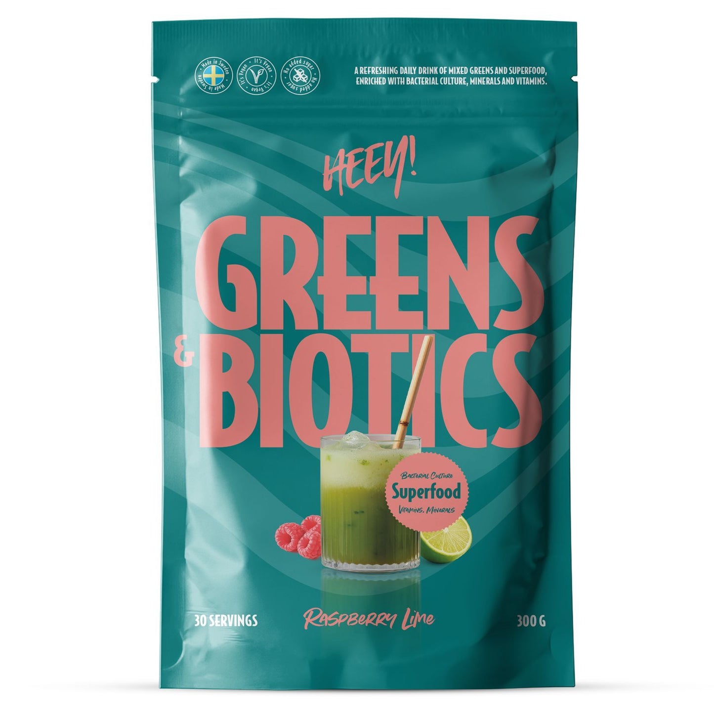 Heey! Greens & Biotics Superfood Raspberry Lime: turkoosi mattapintainen pussi tekstillä "Greens & Biotics" pystyasennossa; pakkauksessa kuvitus lasista vihreää juomaa valkoisella pillillä sekä vadelmien ja limetin kuvitukset vieressä; etuosassa mainitaan "Superfood", "Raspberry Lime" -maku, 30 annosta ja 300 g; valkoinen tausta, ei ihmisiä tai käsiä näkyvissä.