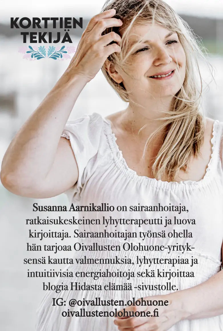 Hidasta Elämää Emotionaalisen palautumisen kortit: pitkähiuksinen vaaleahiuksinen nainen vaaleassa mekossa hymyilee ulkona; kuvassa suomenkielistä tekstiä, joka esittelee hänet Susanna Aarnikalliona, sairaanhoitajana, korttien luojana ja terapeuttina, sekä listaa hänen sosiaalisen median tilinsä ja verkkosivunsa alla; tausta on ulkona luonnonvalossa; tuotepakkausta tai pintoja ei näy kuvassa.