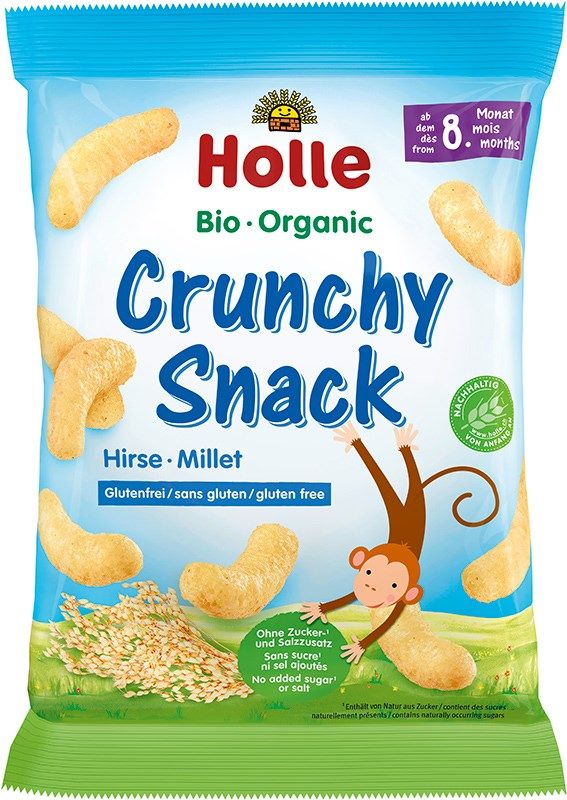 Bag of Holle Bio Organic Crunchy Snack with millet, featuring puffed snacks, a smiling monkey illustration, and product information such as gluten-free and sugar-free, for babies from 8 months. Bag is matte with white and yellow colors, clear panel at bottom showing snacks inside. Sans-serif typography. Product photographed against plain white background in a centered shot. No people or hands.