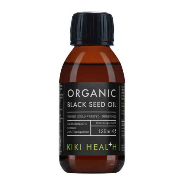 Kiki Health Luomu Mustakuminaöljy; 125 ml:n pullo KIKI Health Organic Black Seed Oil -öljyä mustalla korkilla ja mustalla etiketillä, tiedot kertovat öljyn olevan neitsyt-, kylmäpuristettu, jalostamaton ja ravitseva elintarvikelisä; pullo on sylinterinmuotoinen mattapinnalla; etiketissä valkoista ja vihreää groteskitypografiaa mustaa taustaa vasten; ei ihmisiä tai käsiä näkyvissä; tuote esillä yksinään yksivärista taustaa vasten edestä kuvattuna.