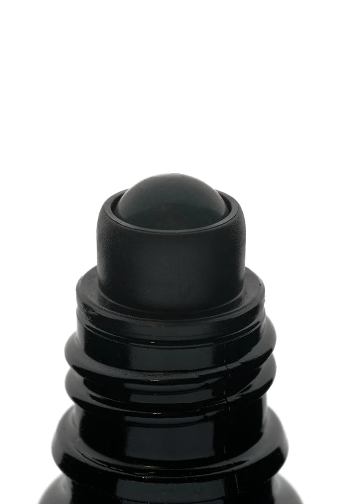 Kuura Essentials Ground Level; lähikuva mustasta pullosta pyöreällä rullapallosovellinosalla, käytetään nesteiden kuten deodorantin tai eteeristen öljyjen annosteluun; pullon pinta sileä ja kiiltäväpintainen ilman näkyvää tekstiä tai etikettejä; muoto sylinterinmuotoinen ja kompakti; pelkistetty valkoinen tausta, ei käsiä, ihmisiä tai muita esineitä kuvassa.