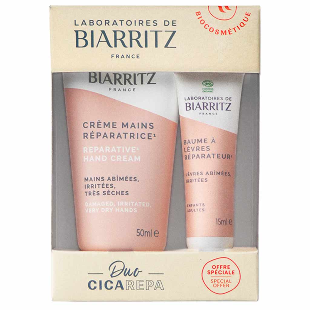 Boxed set of Biarritz France hand cream (50ml) and lip balm (15ml) with pink and white packaging, labeled for damaged, irritated, very dry hands and lips. Both items displayed inside a rectangular box with a matte finish. Notable legible text states product type and intended use. Special offer sticker on lower right—a thoughtful gift from Biarritz France for nourishing everyday essentials. Plain background; no people or hands visible in the image. Shot is a straightforward product-only photo taken from