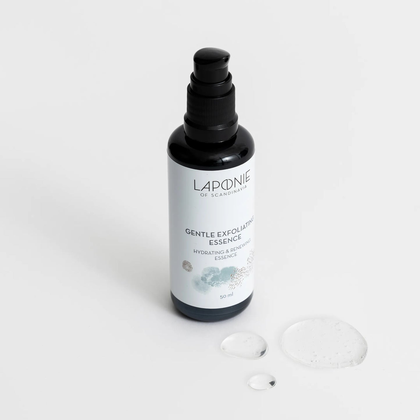 Laponie of Scandinavia Gentle Exfoliating Essence; musta muovinen pumppupullo kiiltopinnalla seisoo pystyssä yhtenäisellä valkoisella taustalla kahden pienen kirkkaan geelipisaran vierellä; etiketissä lukee ”Laponie of Scandinavia Gentle Exfoliating Essence” yksinkertaisella groteskikirjasimella; ei ihmisiä tai käsiä kuvassa; tuote korostaa hellävaraisia kuorintaominaisuuksiaan.