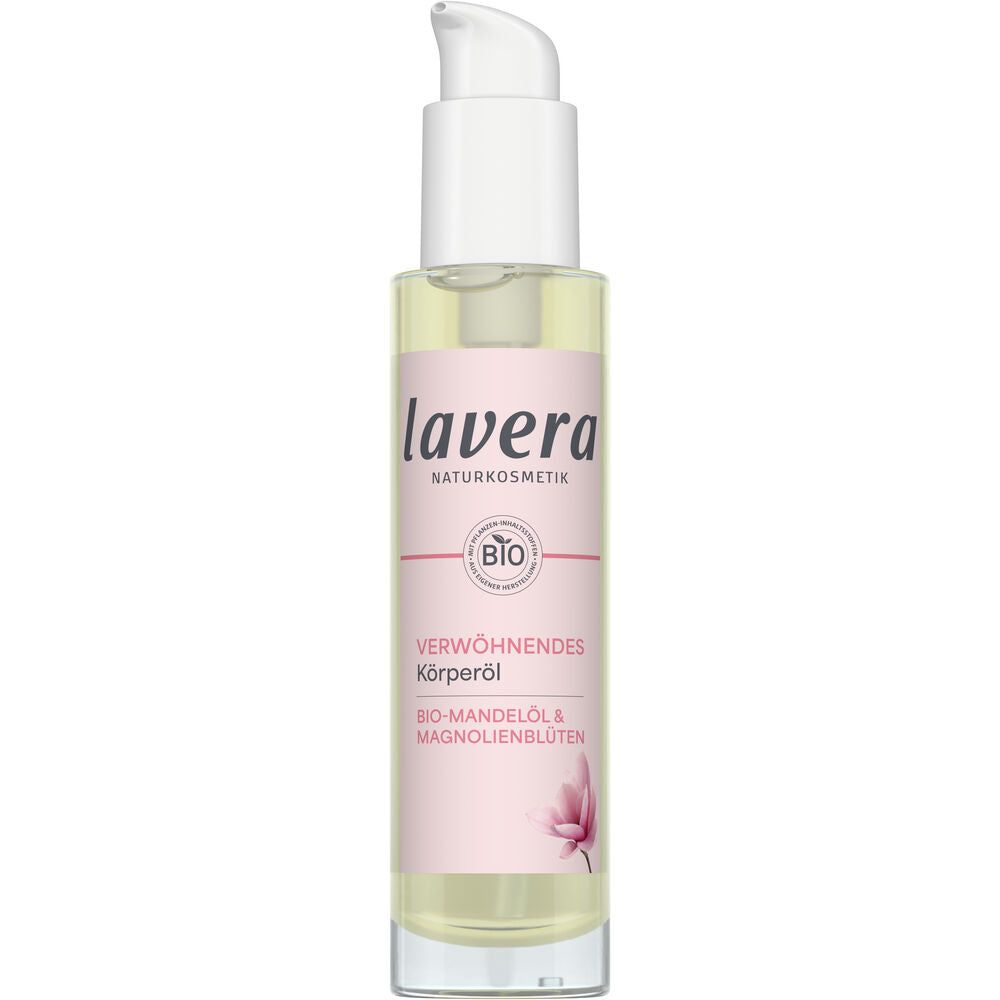 Lavera Indulgent Vartaloöljy; pullo Lavera Naturkosmetik -vartaloöljyä valkoisella muovisella pumppuannostelijalla, lieriömäinen kirkas muovirunko ja kiiltävä vaaleanpunainen kiertoetiketti; etiketissä tikkukirjasintekstiä, joka listaa luomumanteliöljyn ja ravitsevan magnolian kukan; tuotenimi painettu suuremmalla fontilla; pullo yksin tasaisella valkoisella taustalla studiokuvassa.