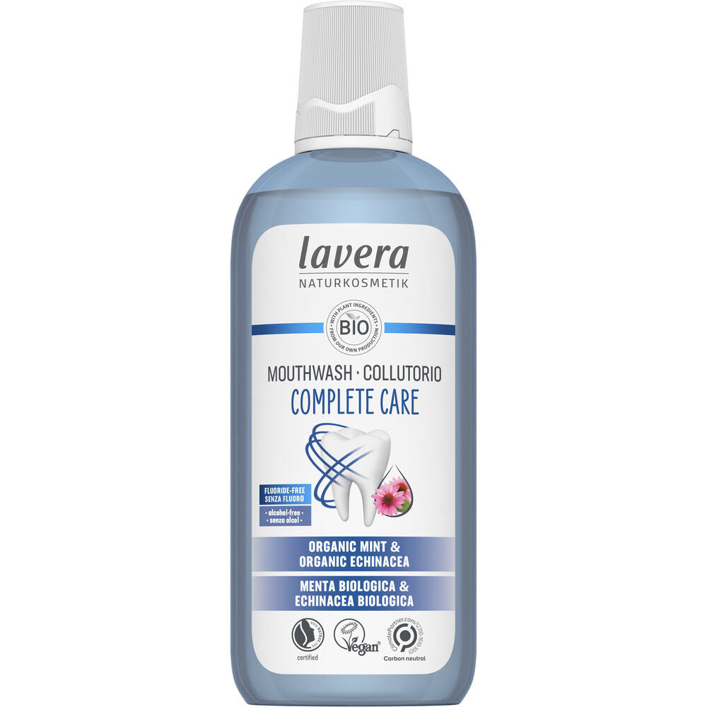 Lavera Complete Care Mouthwash -pullo luomuminttua ja raunioyrttiä sisältävällä suuvedellä; lieriömäinen kirkas muovipullo, jonka läpi näkyy sininen neste, sekä valkoinen kierrekorkki; valkoisessa etiketissä sinisiä yksityiskohtia, groteskitekstiä ja pieniä pyöreitä kuvakkeita vegaanisuudesta ja eläinkokeettomuudesta; pääteksti keskitetty; tausta valkoinen, ei ihmisiä tai rekvisiittaa; tuote kuvattu suoraan edestä.