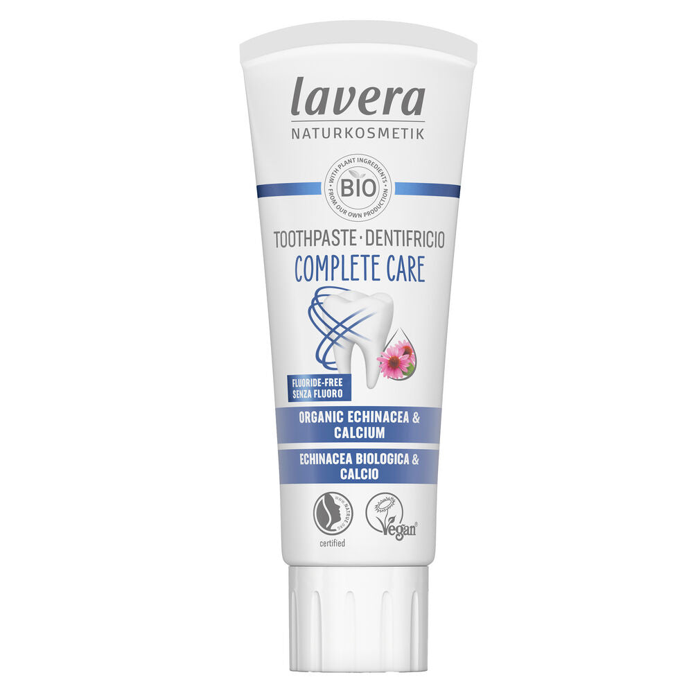 Lavera Complete Care Fluoride-Free -hammastahnaputkilo, jossa luomuraunioyrttiä ja kalsiumia; etiketissä maininnat fluoriditon, vegaaninen ja sertifioitu luonnonkosmetiikka sekä sinisiä ja vaaleanpunaisia yksityiskohtia hellävaraisesta suunhoidosta; putkilo on mattapintaista muovia läppäkorkilla, pääväri valkoinen sinisin ja vaaleanpunaisin yksityiskohdin; tuotenimi groteskikirjasimella etiketissä; kuvassa vain putkilo tasaisella taustalla, ei käsiä tai ihmisiä näkyvissä.