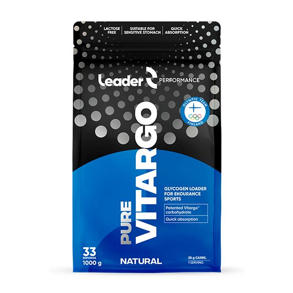 A 1kg black and blue bag of Leader Performance Pure Vitargo, a glycogen loader for endurance sports, featuring quick absorption and lactose-free labels for athletes with sensitive stomachs, and offering 33 servings. Matte flexible pouch with resealable top; bold sans-serif white and yellow typography; front label displays central product name, key features in highlighted blocks. Neutral studio background, no people visible.