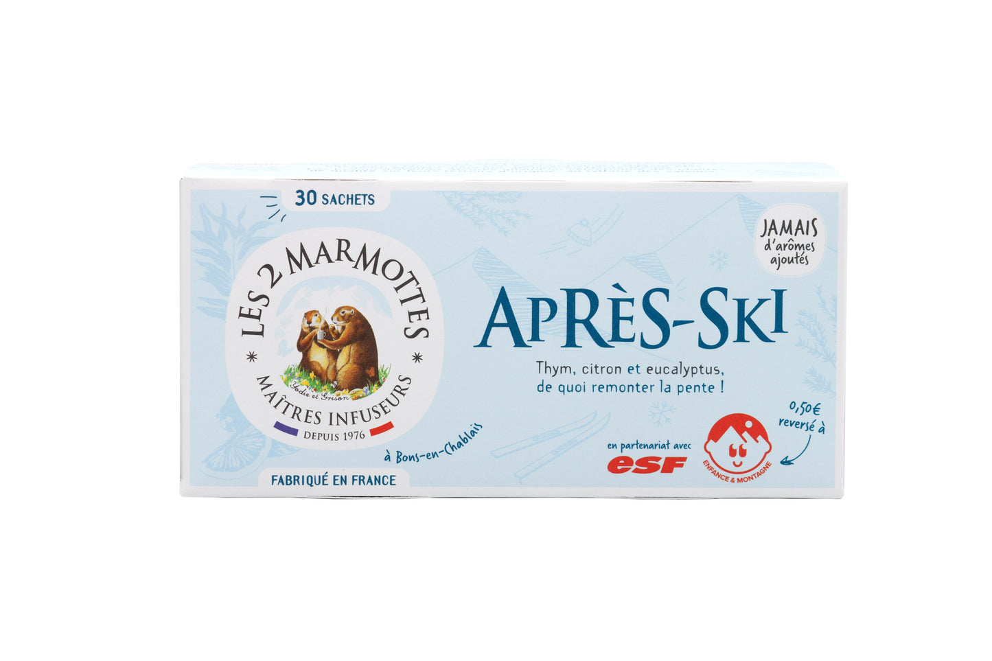 Laatikko Les 2 Marmottes Après-Ski -teetä, sisältää 30 pussia, tunnusomainen murmeli-logo ja ranskankielinen teksti. Yrttisekoitus sisältää timjamia, sitruunaa ja eukalyptusta. Sininen ja valkoinen suorakulmainen pahvilaatikko on mattapintainen. Etiketissä käytetään pääteviivatonta typografiaa. Tuote on aseteltu yksiväriselle taustalle studiotyyliseen kuvaan.