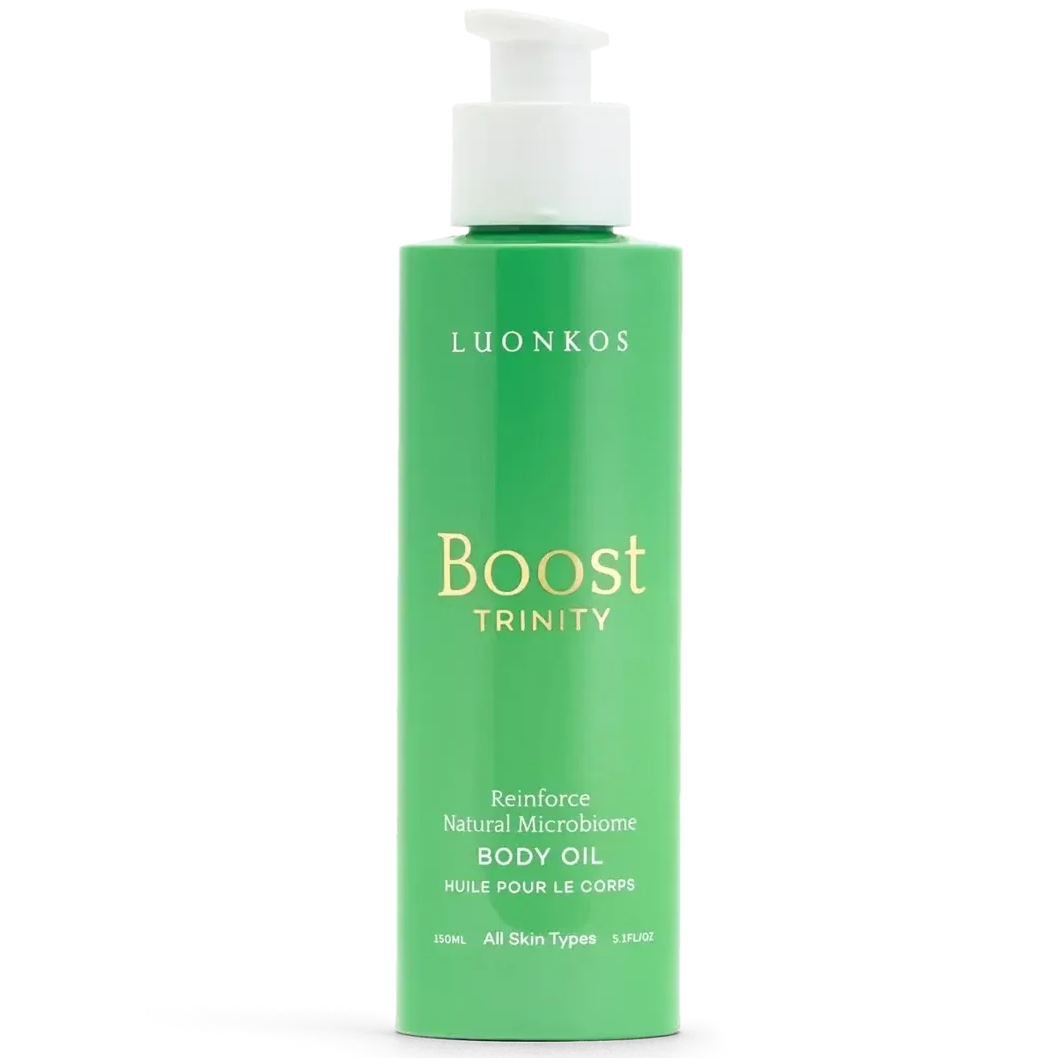 Luonkos Boost Trinity Body Oil; vihreä pullo Luonkos Boost Trinity -vartaloöljyä valkoisella pumppuannostelijalla; pullo lieriömäinen mattapinnalla; etiketti aseteltu pystysuoraan, yksinkertaista groteskitekstiä; etiketin avainlauseet: all skin types ja natural microbiome; tausta yksinkertainen; ei ihmisiä tai käsiä kuvassa.