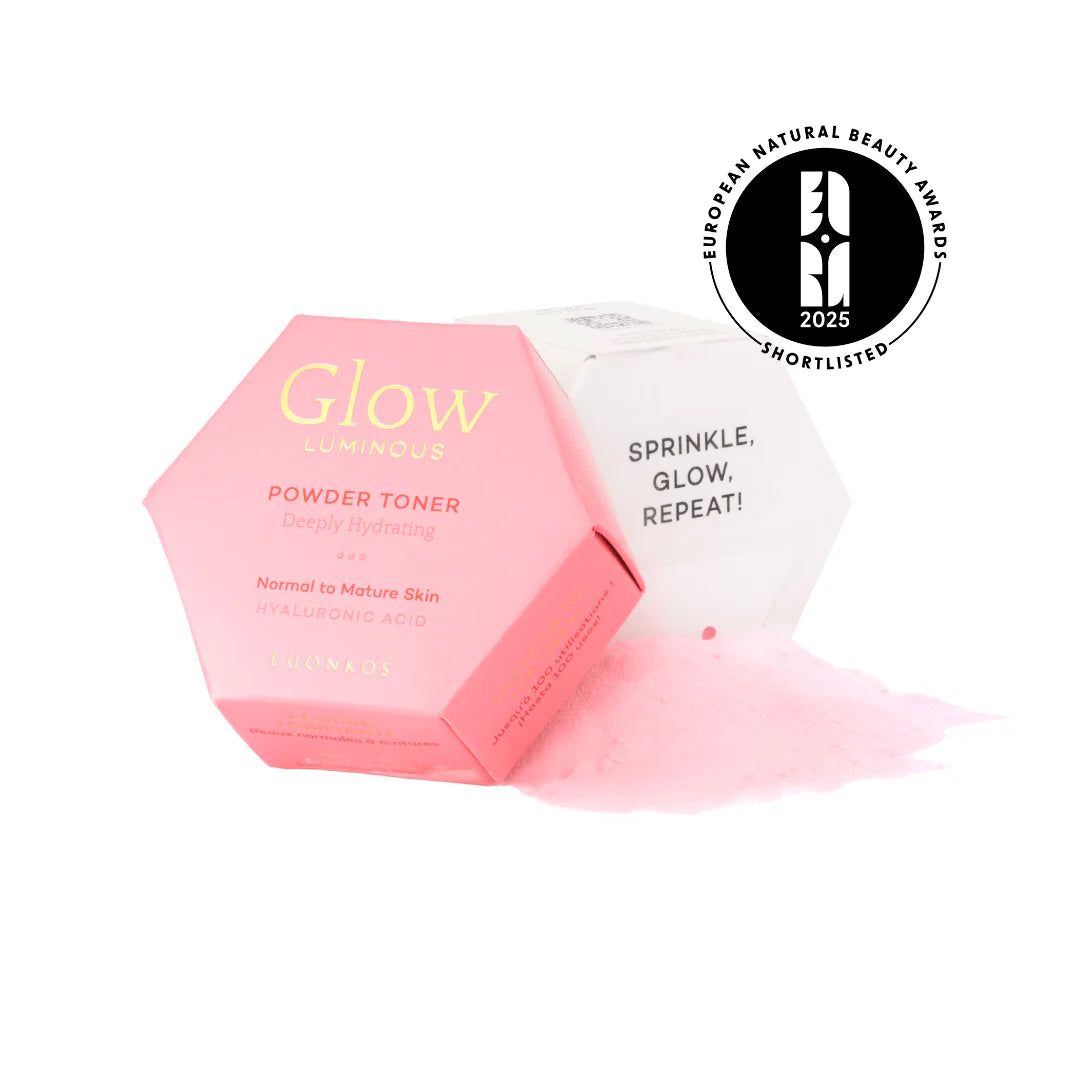 Luonkos Glow Luminous Powder Toner; vaaleanpunainen kuusikulmainen astia Glow Luminous Powder Toner -tuotetta läikkyneen vaaleanpunaisen jauheen kera, vieressä valkoinen suorakaiteen muotoinen rasia tekstillä ”Sprinkle, Glow, Repeat!” lihavoiduin mustin kirjaimin; oikealla näkyvissä European Natural Beauty Awards 2025 -listamerkintä; tausta tasainen valkoinen; ei ihmisiä tai käsiä näkyvissä kuvassa.