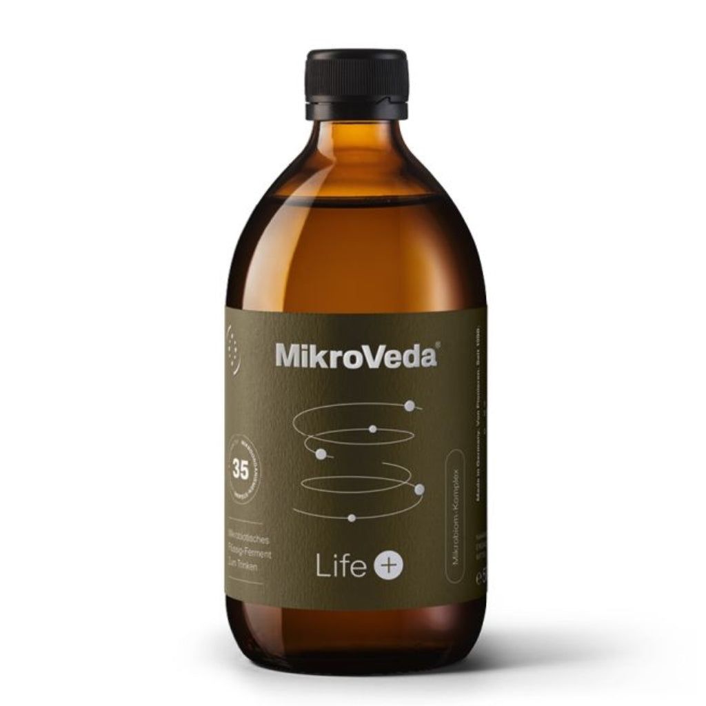 MikroVeda Life+ -pullo; ruskea, kiiltäväpintainen lasipullo mustalla, mattapintaisella kierrekorkilla; vihreässä etiketissä valkoista tekstausvapaata tekstiä sekä pyöreitä kuvioelementtejä ja numeroita; kuvattu edestä pystyssä keskellä kuvaa valkoista taustaa vasten, ei ihmisiä tai käsiä näkyvissä.