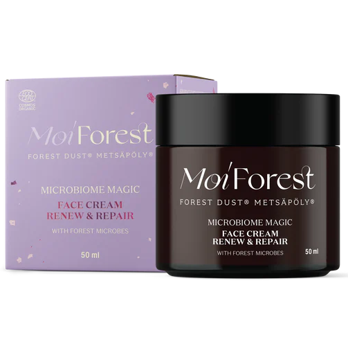 Moi Forest Microbiome Magic Face Cream; 50 ml purkki Moi Forest Microbiome Magic -kasvovoidetta violetin ja valkoisen pakkauksen vieressä; purkissa valkoinen kansi ja lieriömäinen muoto, molemmat mattapintaisia; groteskityypografia pakkauksessa; luettavassa etiketissä teksti Renew & Repair, metsän mikrobit ja ihon mikrobiomi; tausta yksinkertainen, ei ihmisiä tai käsiä.
