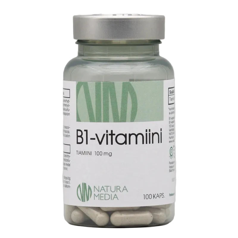 Natura Media B1-vitamiini 100 mg: läpinäkyvä sylinterimäinen muovipurkki, jonka läpi näkyy valkoisia kapseleita, sisältää 100 kapselia; korkki on sileä, heijastava hopeanvärinen kierrekorkki; etiketissä musta-kultainen teksti "B1-vitamiini TIAMIINI 100 mg" selkeällä groteskikirjasimella valkoisella pohjalla; tuote kuvattu valkoista taustaa vasten tasaisessa valaistuksessa.