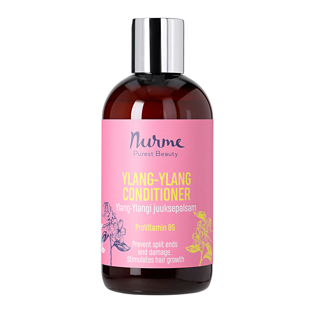 Nurme Ylang Ylang Hoitoaine; pullo Nurme Purest Beauty Ylang-Ylang Conditioner -tuotetta vaaleanpunaisella etiketillä, kukkakuvituksin ja valkoista tikkukirjasintekstiä listaten pro-vitamiini B5:n sekä hyötyjä kuten halkeamien ehkäisyn ja hiusten kasvun stimuloinnin; pullo lieriömäinen, muovia mattapinnalla; tausta tasainen valkoinen; ei ihmisiä tai käsiä näkyvissä.