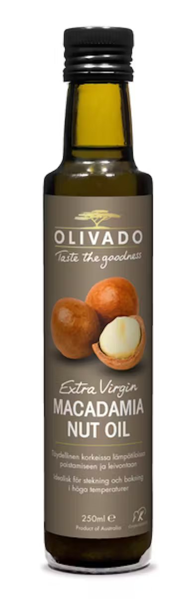 Olivado Macadamiaöljy-pullo, jossa ruskea kiiltäväpintainen etiketti ja kuvat kokonaisista ja rikotuista macadamiapähkinöistä; pullo on lieriömäinen tummasta lasista, koko 250 ml; etiketissä luettavissa tuotenimi ja alkuperätiedot; tausta yksinkertainen ja neutraali, ei ihmisiä tai käsiä näkyvissä.