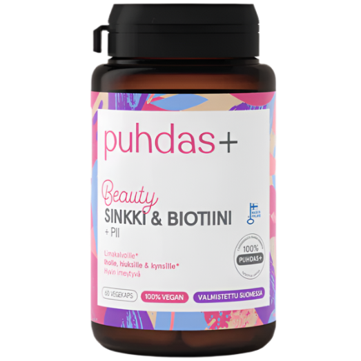 A bottle of Puhdas+ Beauty Sinkki & Biotiini supplements with a colorful, glossy label. The cylindrical plastic bottle has a white cap and displays Finnish text along with icons for 100% vegan and made in Finland. Typography is clear and sans-serif. The shot is a close-up on a plain background, no people or hands visible. A bottle of Puhdas+ Beauty Sinkki & Biotiini supplements with a colorful label, featuring Finnish text and icons indicating it is 100% vegan and made in Finland. This supplement combines