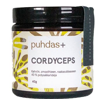 A brown, matte-finish jar with a screw-top lid displays the label “puhdas+ Cordyceps,” featuring yellow and green abstract designs and Finnish text. The container is cylindrical with clean edges. Label typography uses a simple sans-serif font. No people or hands are present. Background is plain white, image is a straightforward product shot.