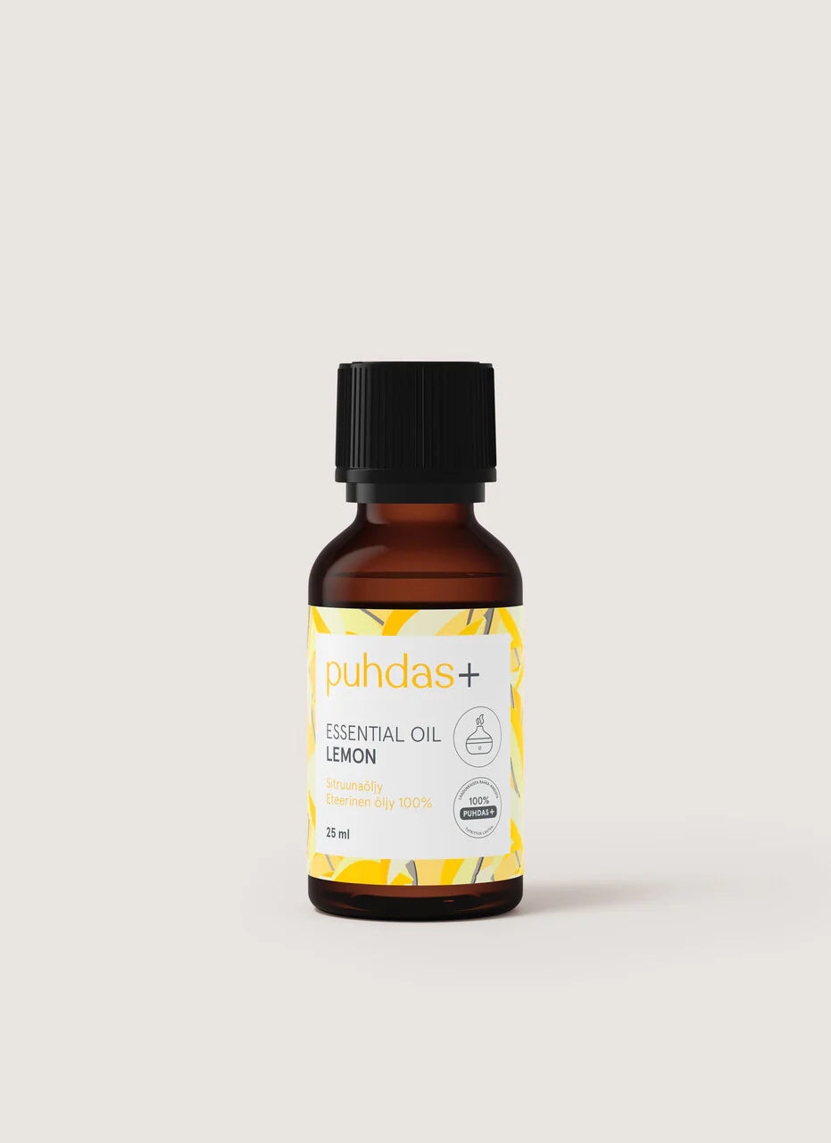 puhdas+ Essential Oil Lemon -pullo, pieni ruskea pullo mustalla korkilla, keltaisia lehtikuvioita ja tekstiä, joka ilmoittaa 100-prosenttisesti puhtaan sitruunaöljyn, 25 ml; pullo sylinterimäinen mattapinnalla ja kierrekorkilla; etikettityyli siistiä modernia tekstausvapaata mustaa ja keltaista tekstiä; tausta yksinkertainen ja vaalea, ei rekvisiittaa tai ihmisiä näkyvissä; kuva edestäpäin otettu tuotekuva.