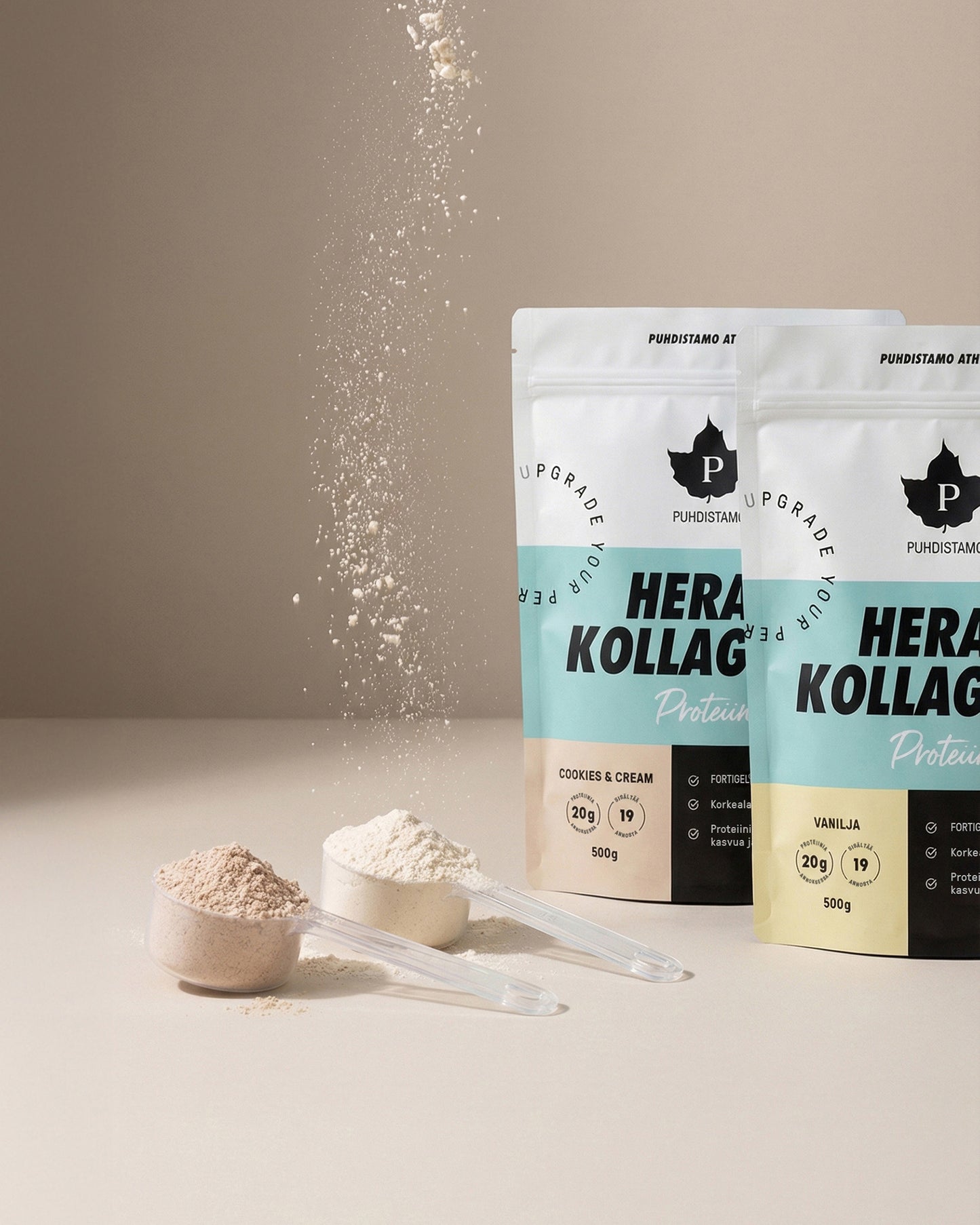 Puhdistamo Hera & Kollageeni Vanilja; kaksi Puhdistamo Herakollagen-proteiinijauhepussia, toinen vanilja- ja toinen cookies & cream -makuinen, edessä jauhetta täynnä olevat mittalusikat; kollageenipöly valuu yläreunasta alaosaan kuvassa; matat pussit uudelleensuljettavalla yläreunalla, tuotenimi ja maku lihavoidulla groteskilla; pussit pystyssä neutraalilla sileällä pinnalla, ei ihmisiä tai käsiä kuvassa.