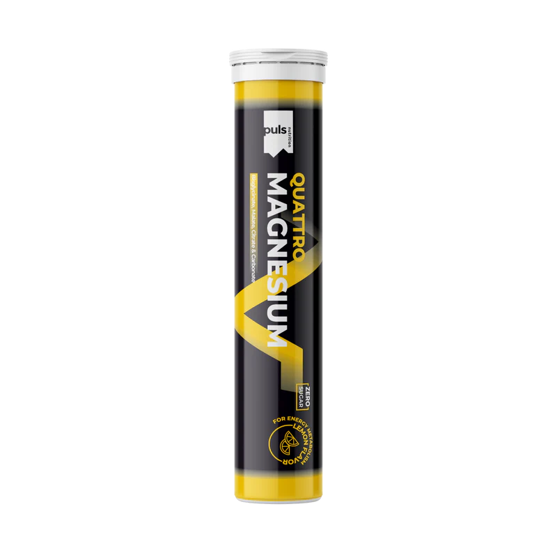Puls Quattro Magnesium Sitruuna poretabletti: musta-keltainen putkilo tekstillä "QUATTRO MAGNESIUM" näkyvällä brändäyksellä, poretablettilisä energiaan ja luuston tukeen; sylinteri on muovia, kiiltäväpintainen, valkoinen korkki, seisoo pystyssä yhtenäisellä valkoisella taustalla; kirjasin on lihavoitua, osittain versaalilla kirjoitettua; ei ihmisiä tai muita esineitä näkyvissä.