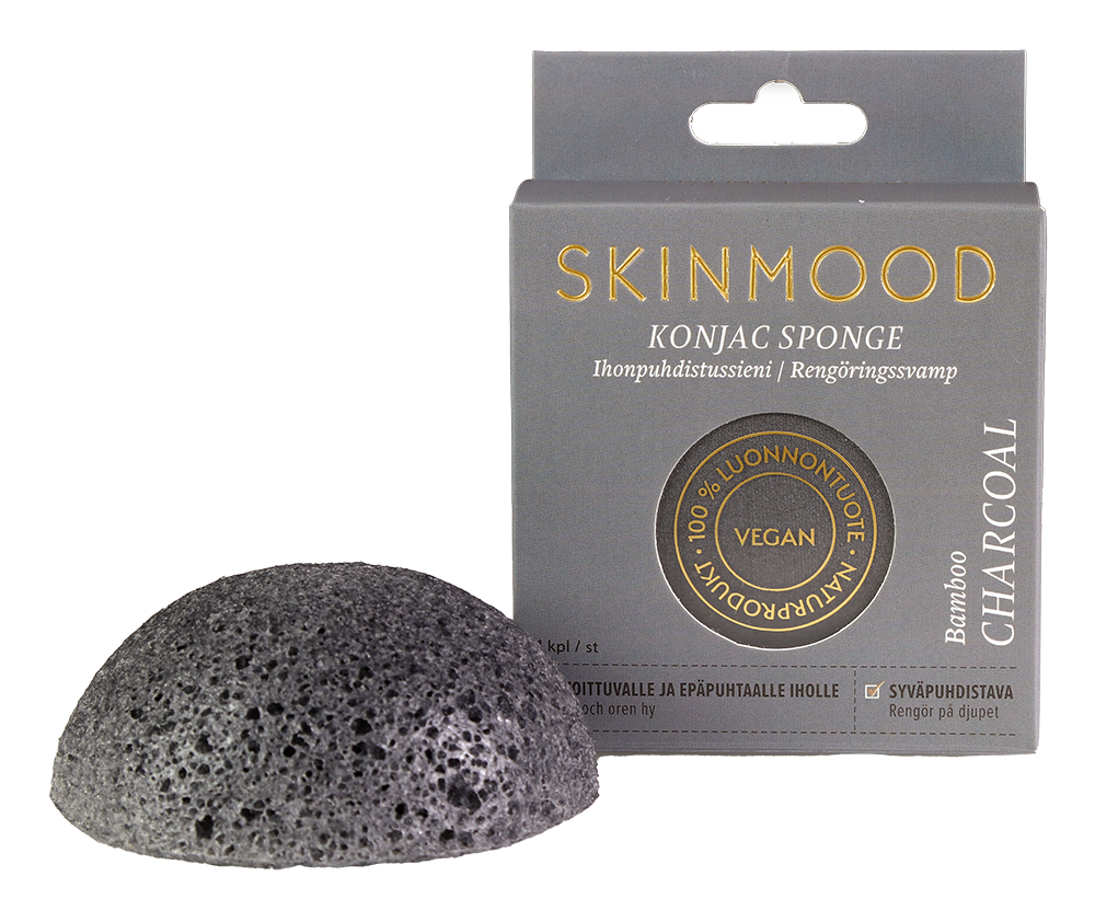 SkinMood Magical Konjac Sponge Bamboo Charcoal -pesusieni; musta, pyöreä ja mattapintainen sieni pystyssä suorakulmaisen pakkauksensa edessä; pakkauksessa kultaista ja valkoista tekstausvapaata tekstiä sekä pyöreitä vegaani- ja luonnontuotemerkkejä; molemmat kuvattu valkoista taustaa vasten, ei ihmisiä tai käsiä näkyvissä.