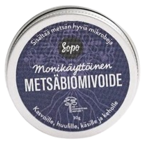 Pyöreä metallipurkki merkinnällä Sopo Monikäyttöinen Metsäbiomivoide, valkoisella tekstillä tummansinisellä pohjalla. Purkki on mattapintainen ja siinä on yksinkertainen, versaalikirjaimin kirjoitettu pääteviivaton fontti. Suomenkielinen teksti mainitsee käyttökohteiksi kasvot, huulet, kädet ja vartalon. Tuote lepää tekstuurittomalla valkoisella pinnalla. Ihmisiä tai käsiä ei näy kuvassa.