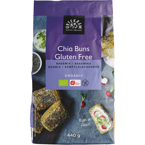 Urtekram Gluteeniton Luomu Chia Leipäjauhoseos; violetti Urtekram-gluteenitonluomu Chia Buns -leivontajauhepussi mattapinnalla, suorakulmainen ja pystyssä seisova; etiketissä valokuvia pyöreistä chia-sämpylöistä tasaisella alustalla, osa koristeltu tuorejuustolla ja retiisiviipaleilla; teksti kertoo runsaasta kuitupitoisuudesta ja 440 gramman painosta selkeällä groteskikirjasimella; tasainen tausta, ei ihmisiä tai käsiä.