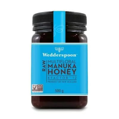 Wedderspoon Manuka-hunaja KFactor 12 -purkki, 500 g; sylinterinmuotoinen mattapintainen purkki mustalla kierrekannella, sininen etiketti tekstillä "Product of New Zealand" ja "non-GMO verified"