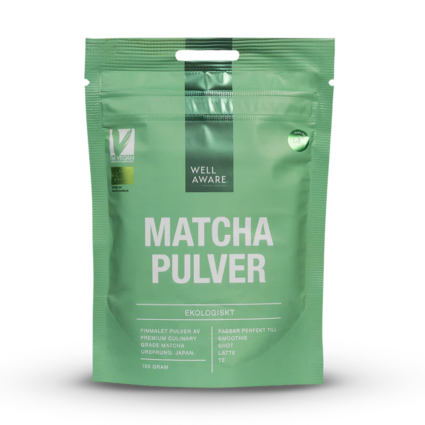 WellAware Luomu Matcha jauhe; vihreä uudelleensuljettava pussi tekstillä Well Aware Matcha Pulver Ekologiskt, näyttää vegaani- ja luomusymboleita ja korostaa matchan kulinaarista alkuperää Japanista; pakkaus matta ja suorakulmainen selkeällä groteskikirjasimella; symbolit sijoitettu pääotsikon alle; valkoinen tausta, ei ihmisiä tai rekvisiittaa.