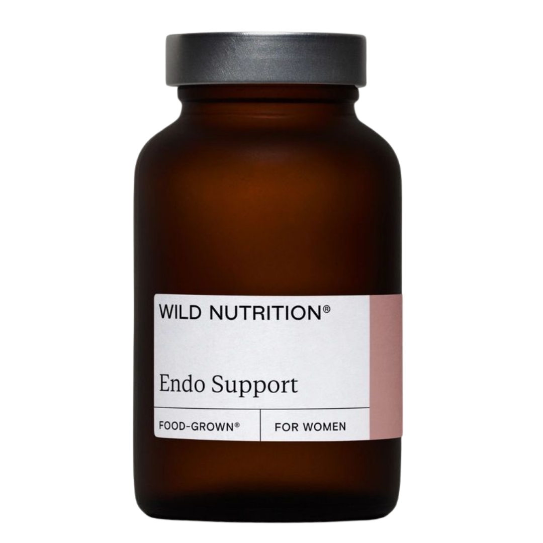 Wild Nutrition Endo Support; ruskea lasipullo tekstillä Wild Nutrition Endo Support, vaaleanpunainen ja valkoinen Food-Grown-etiketti naisille, kuvattu valkoista taustaa vasten; pullo sylinterin muotoinen kierrekorkilla ja mattapinnalla; etikettikirjasin lihavoitua groteskia tuotenimessä; ei ihmisiä, käsiä tai rekvisiittaa kuvassa, suoraviivainen tuotekuva.